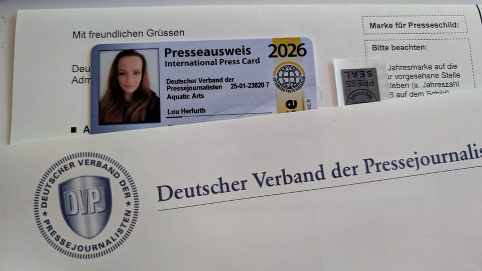 Ein internationaler Presseausweis und Unterlagen des Deutschen Verbands der Pressejournalisten liegen teilweise sichtbar auf einem Schreibtisch
